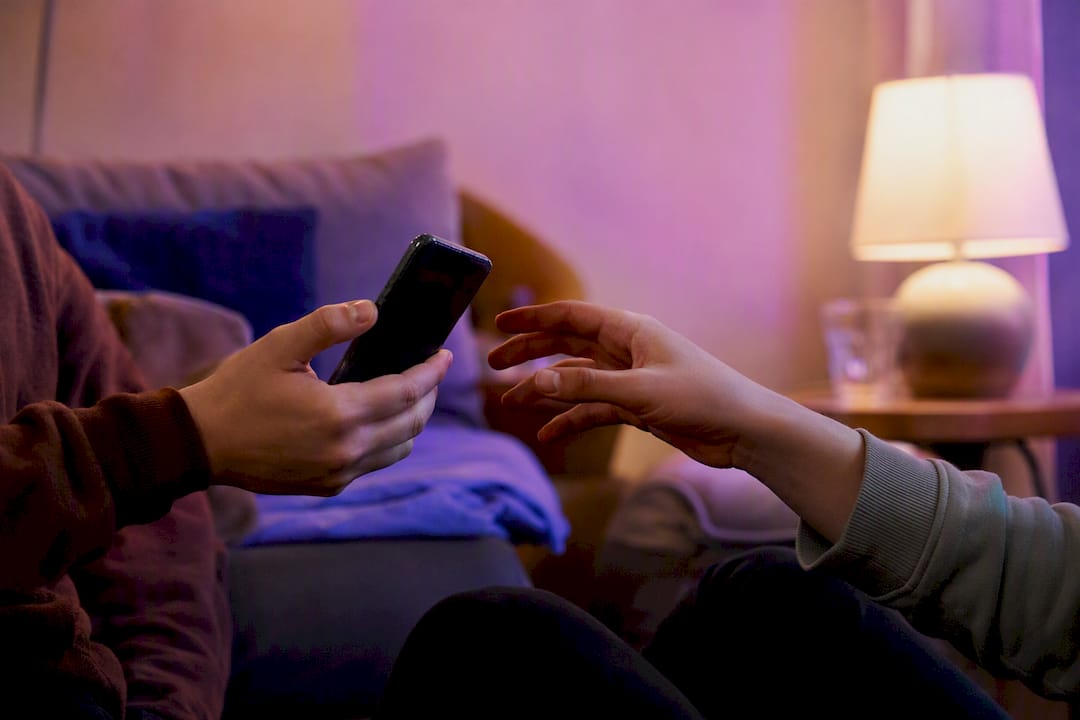 Hands sharing music quiz results on smartphone
