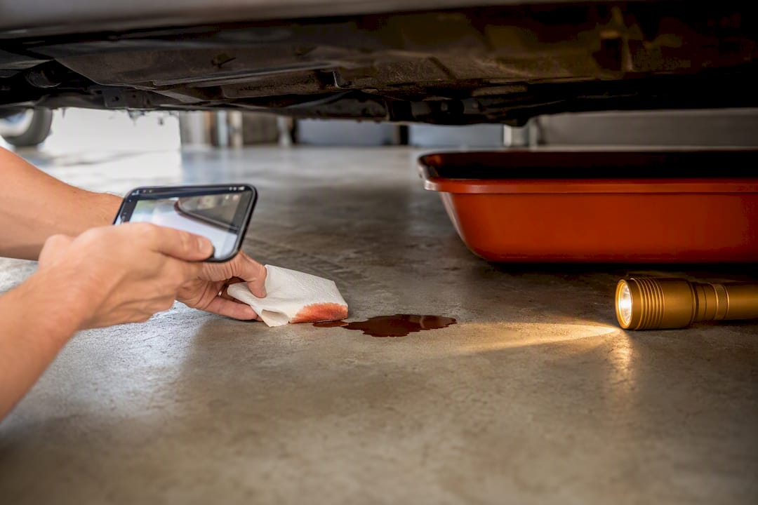 Owner checking transmission fluid puddle