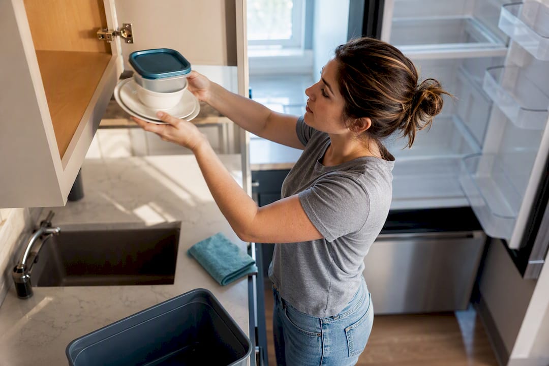 Renter clearing kitchen cabinets before cleaning