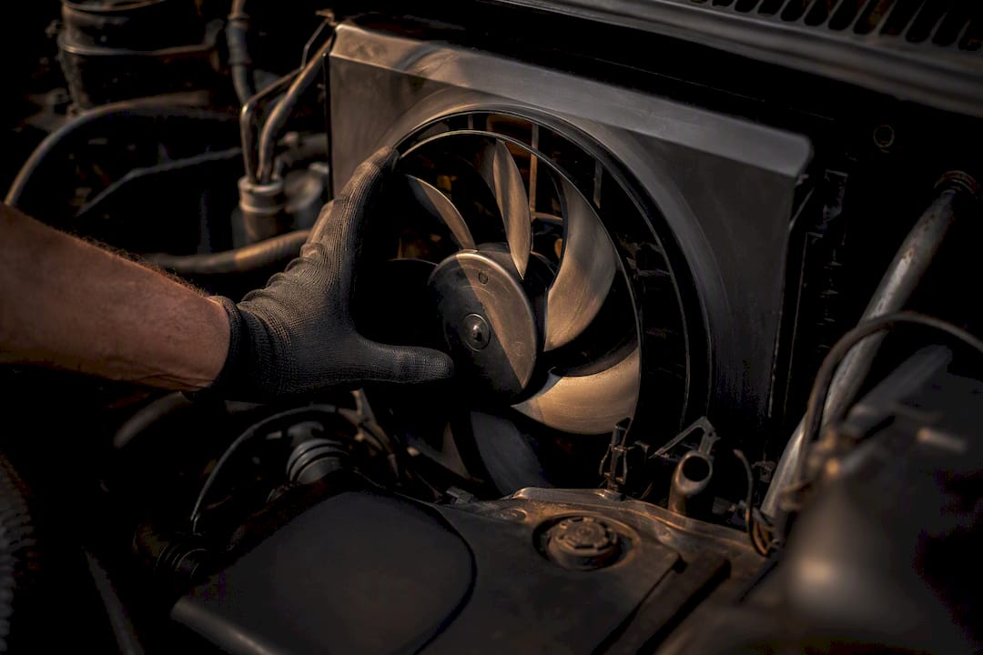 Hand checking car aircon cooling fan blades