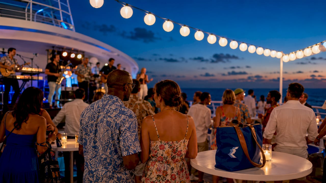 Passengers enjoying live music on cruise deck at sunset