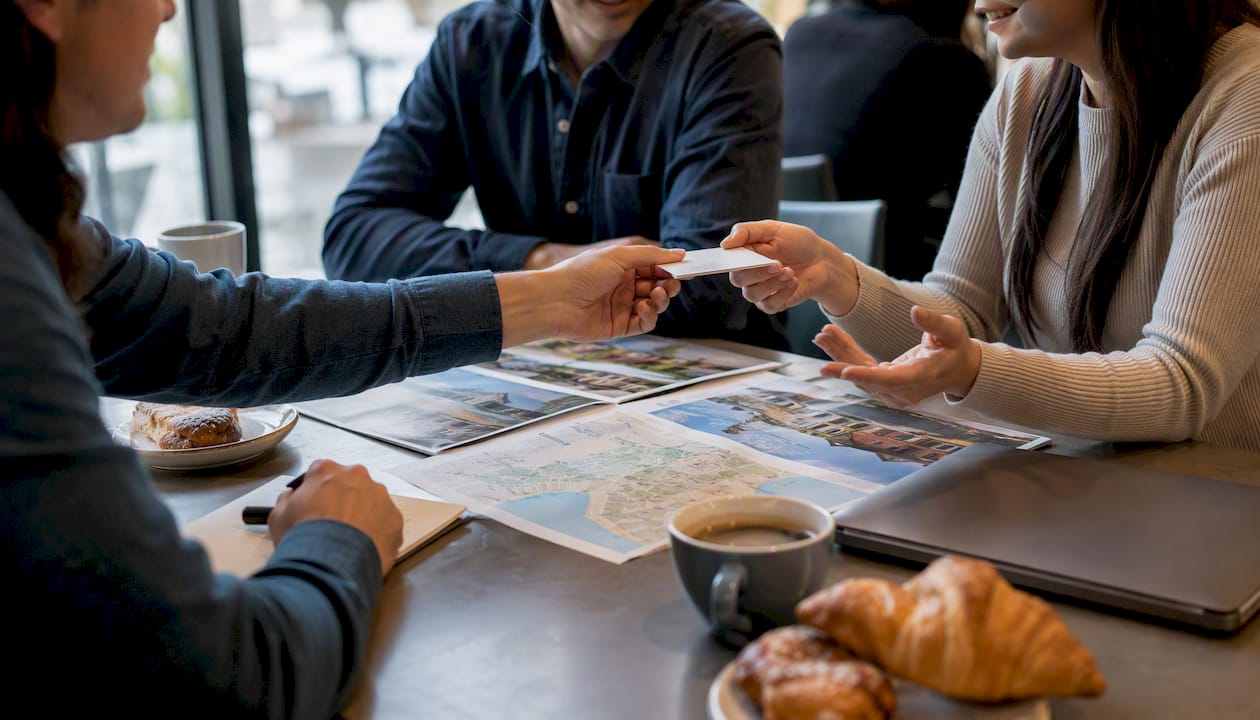 Hands exchanging cards and plans at real estate club
