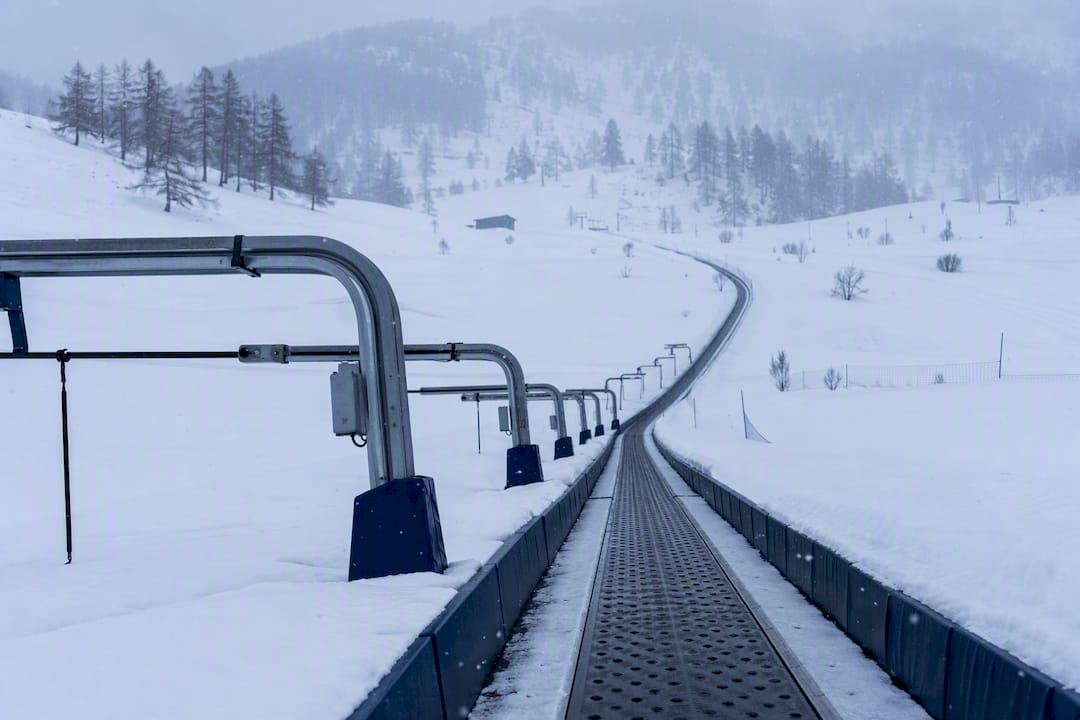 Child skiing on a magic carpet conveyor lift