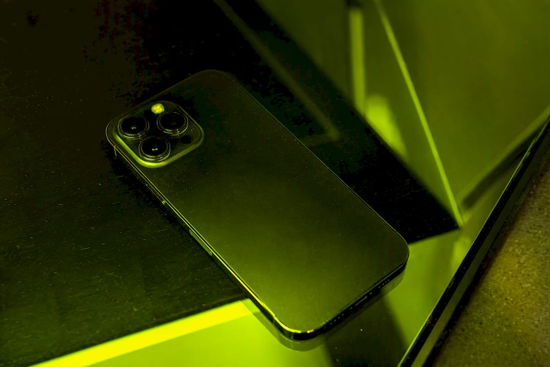 Smartphone lying face down on dark neon-lit desk