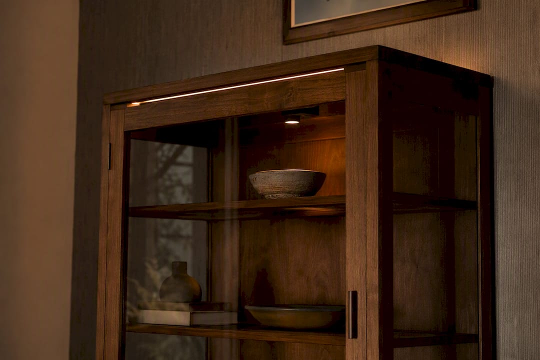 Wooden display cabinet with layered accent and wash lighting
