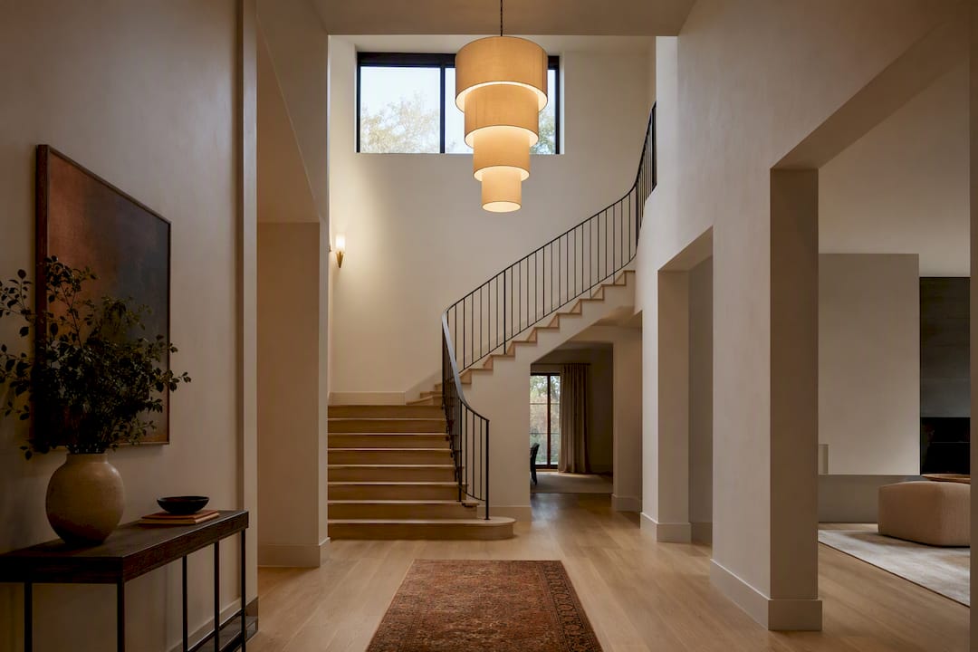 Warm chandelier lighting a double-height foyer