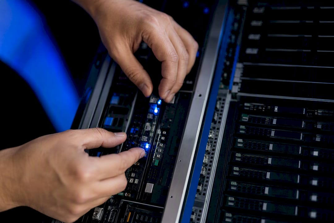 Hands adjusting controls on server hardware