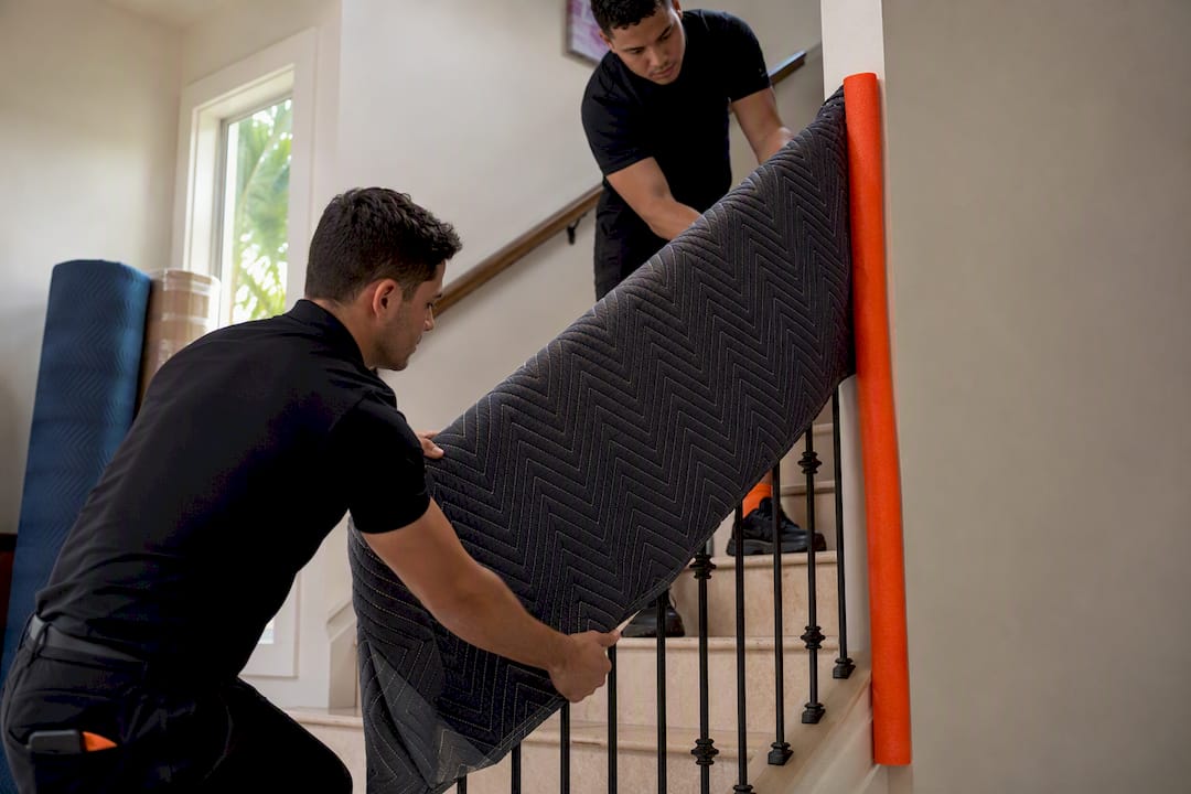 Movers protecting stair railings and walls