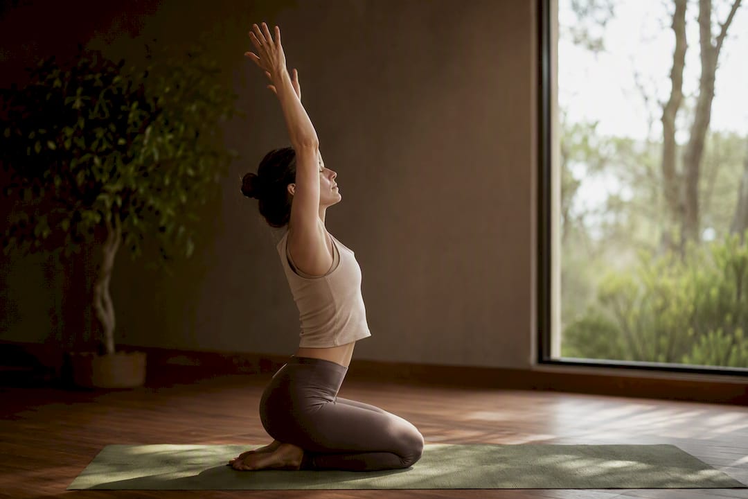 Persona levantando los brazos al inhalar durante yoga