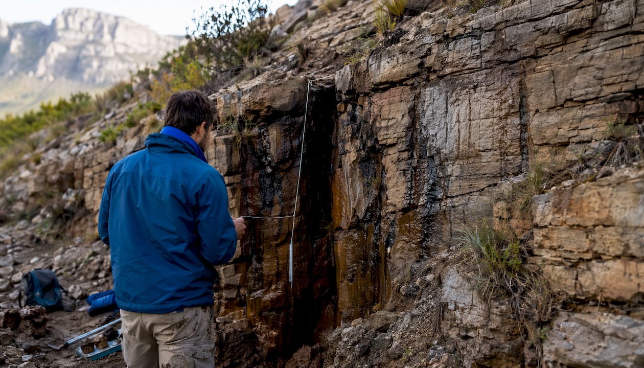 Fractured sandstone rock with geologist's hands
