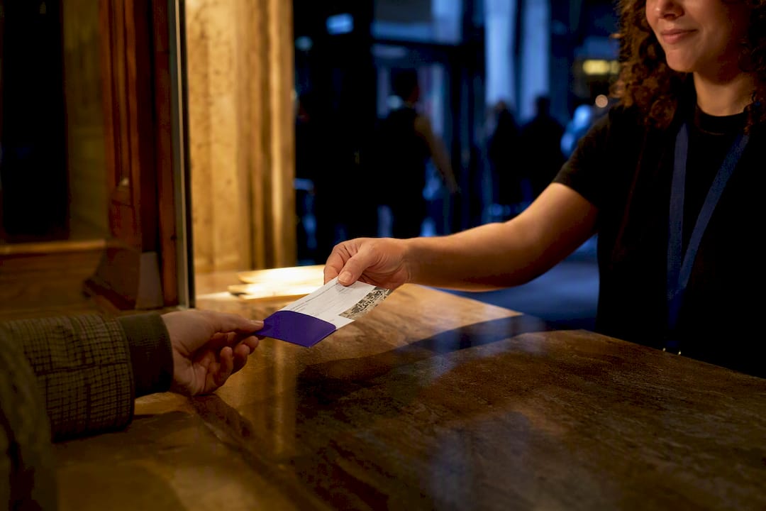 Hands completing an offline box office ticket purchase