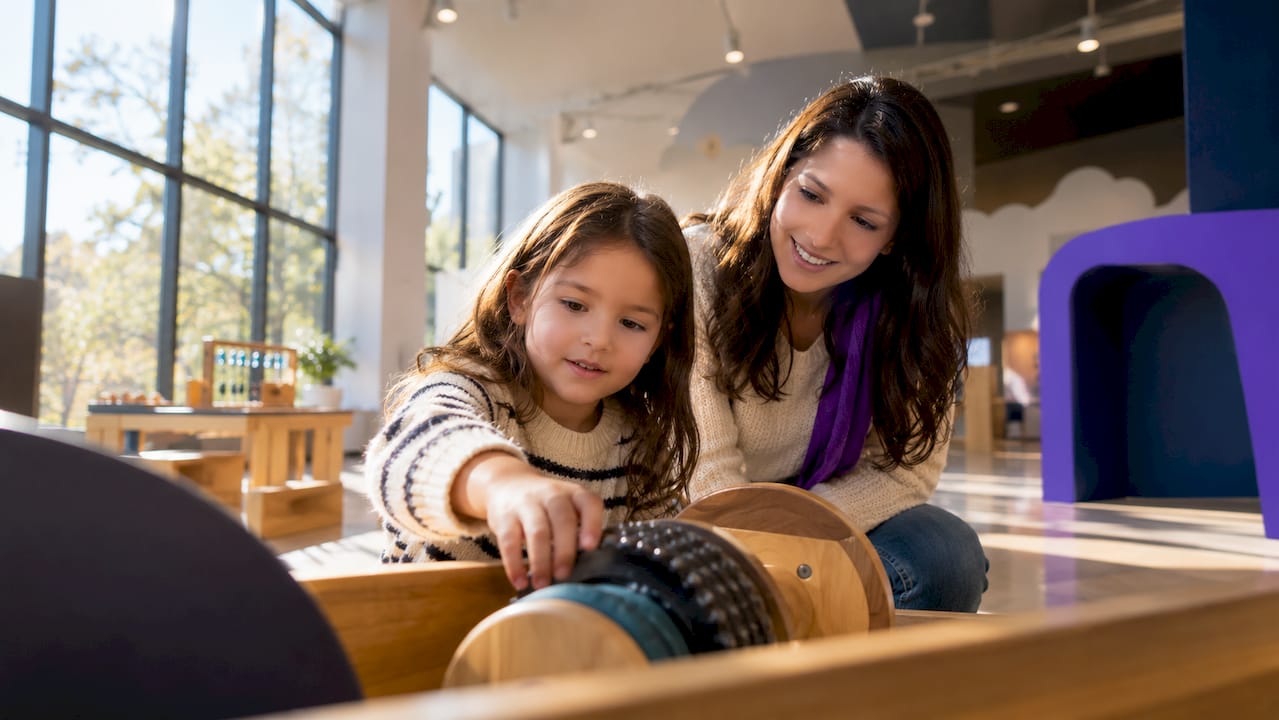 Caregiver and child exploring museum exhibit