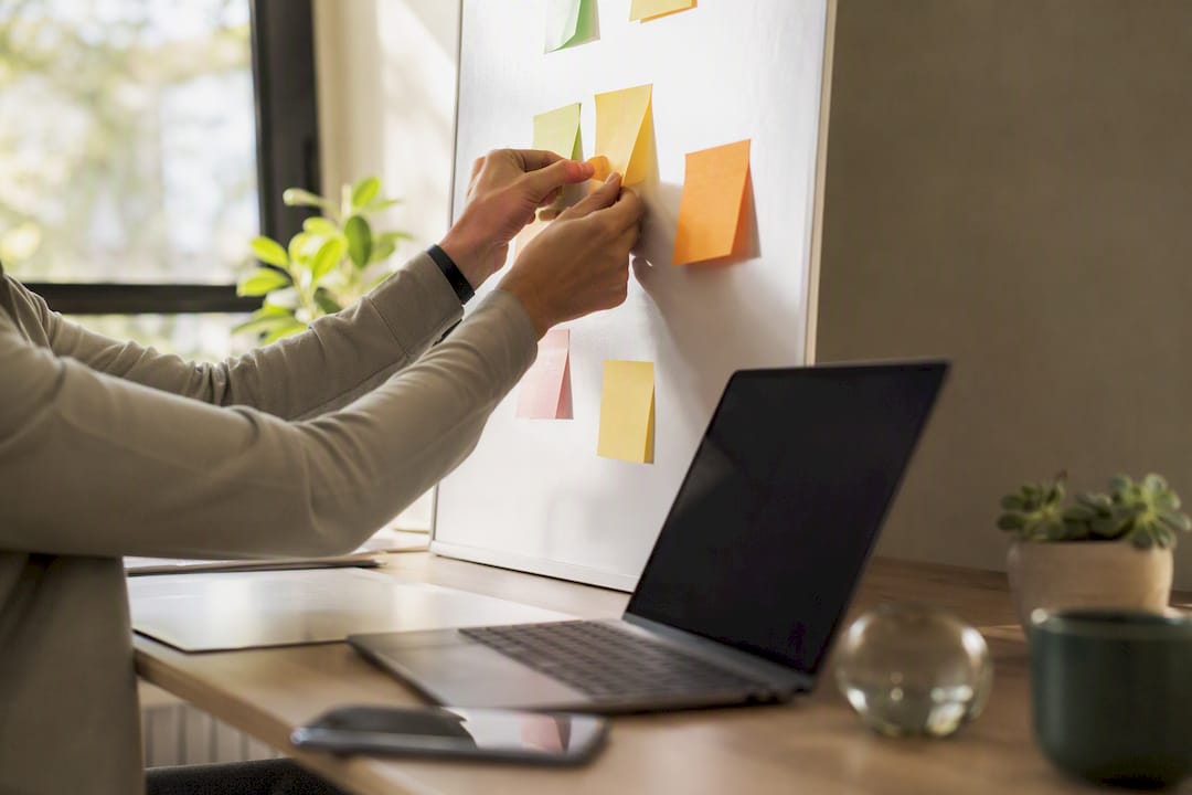 Hands placing follow-up note on office desk