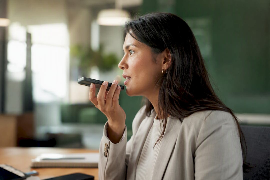 Person holding phone on voice call in office
