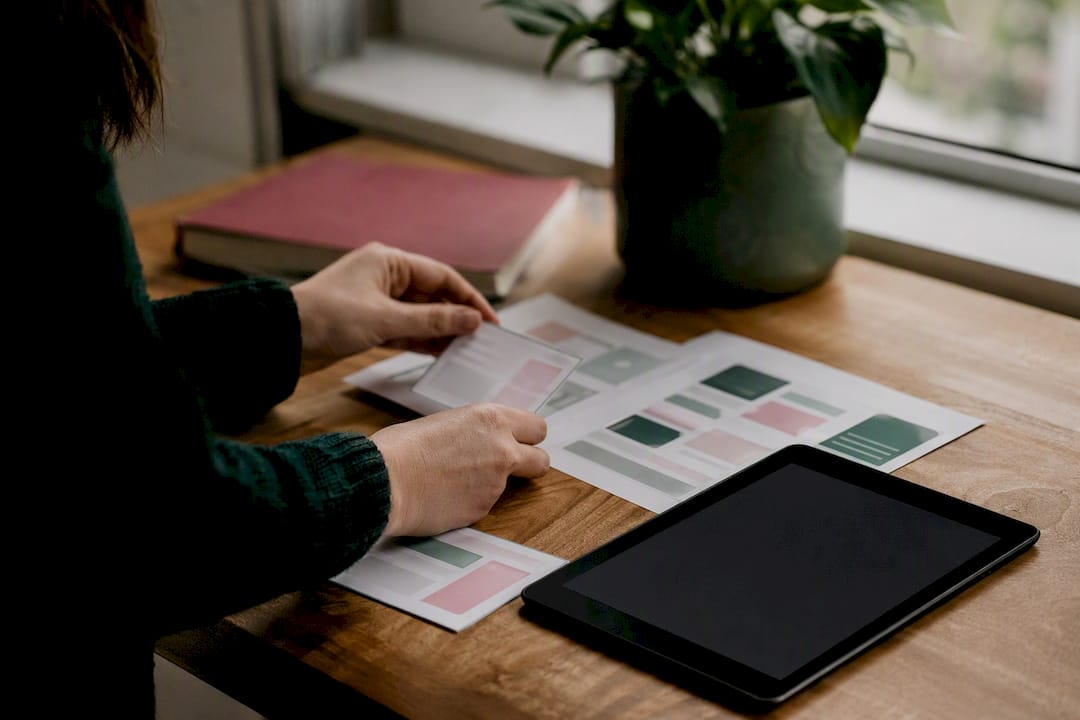 Hands arranging website wireframes on desk