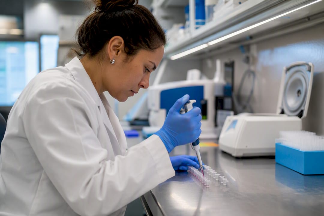 Hands pipetting antibody reagents at lab bench