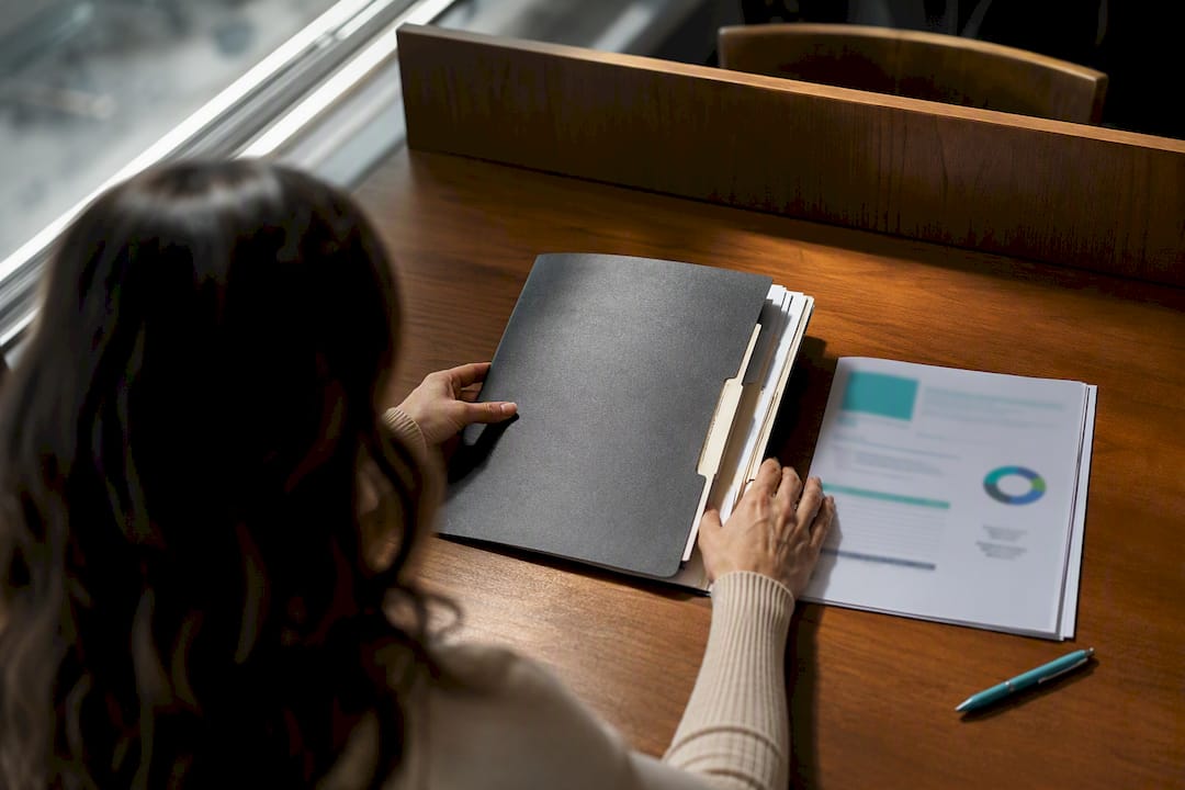 Hands organizing foreclosure recovery documents