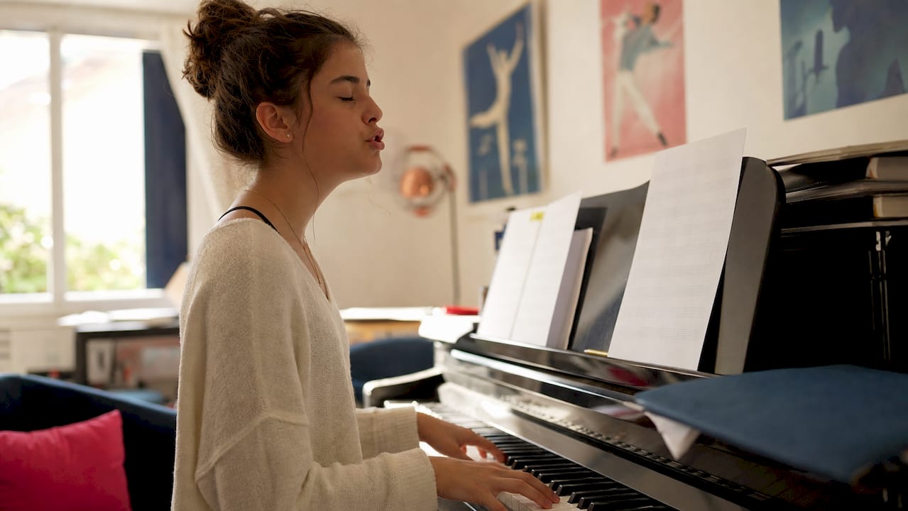 Teen practicing vocal scales at piano