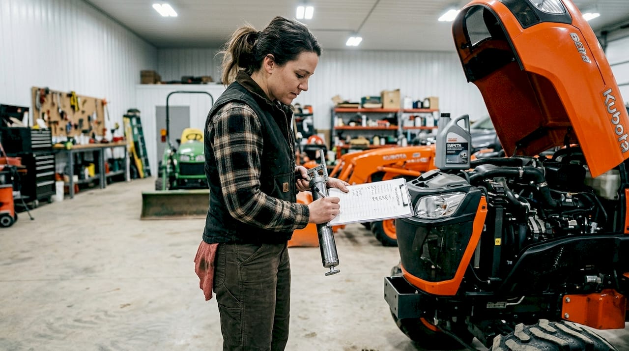 Operator using lubrication checklist on tractor