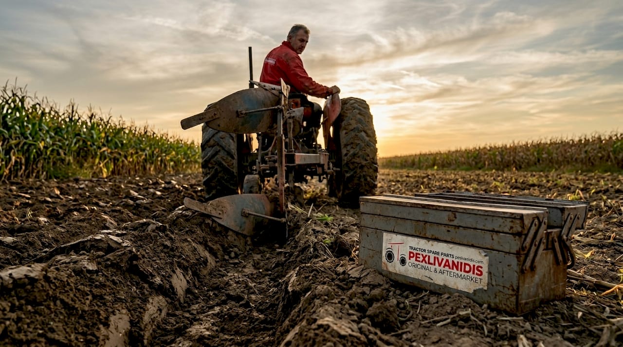 Farmer operating moldboard plough on field