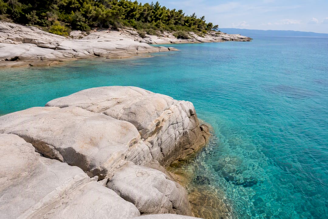 Rock ledges descending into turquoise sea at Kavourotrypes