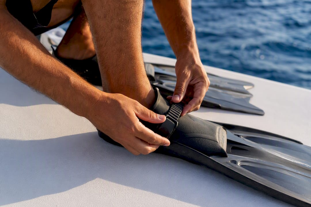 Hands adjusting snorkel fins strap