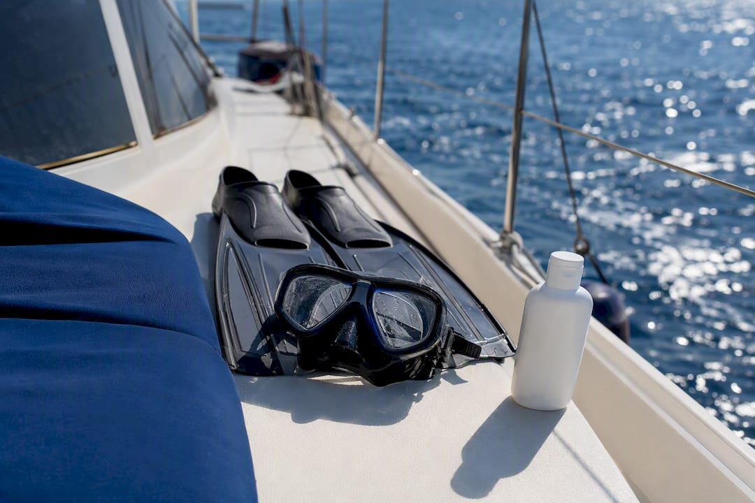 Snorkeling gear and spray sunscreen on sailing boat deck