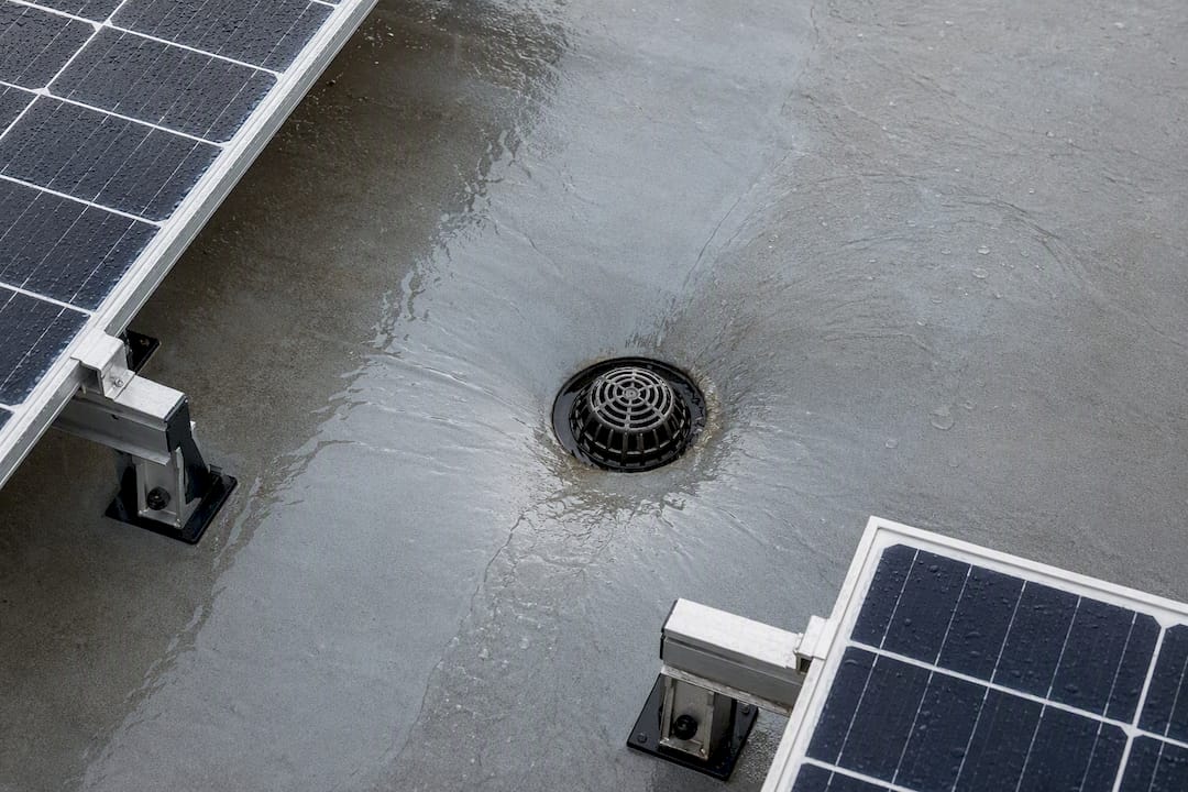 Rainwater flowing toward flat roof drain