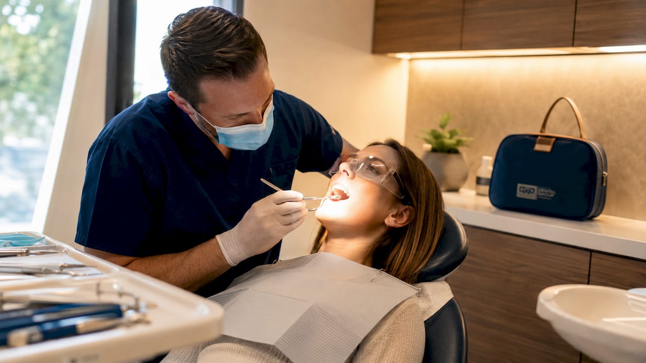 Dentist performing oral exam in dental clinic