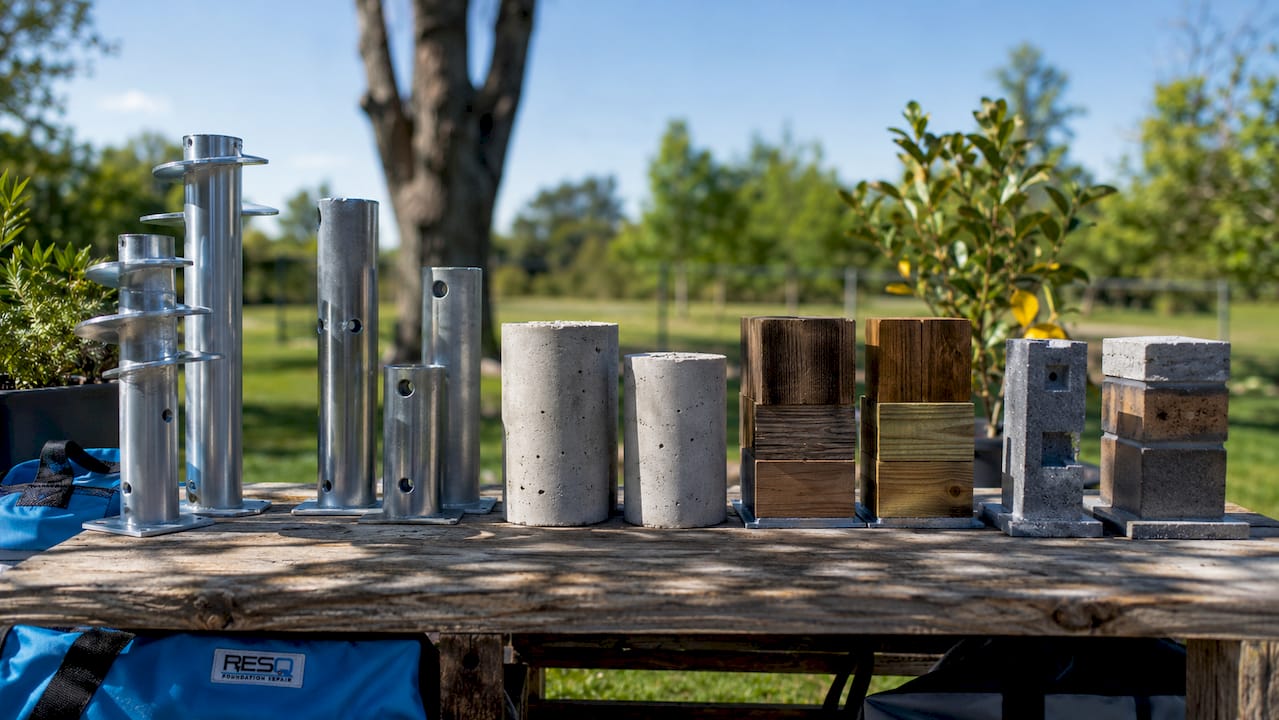 Close-up of assorted foundation repair pier samples on workbench