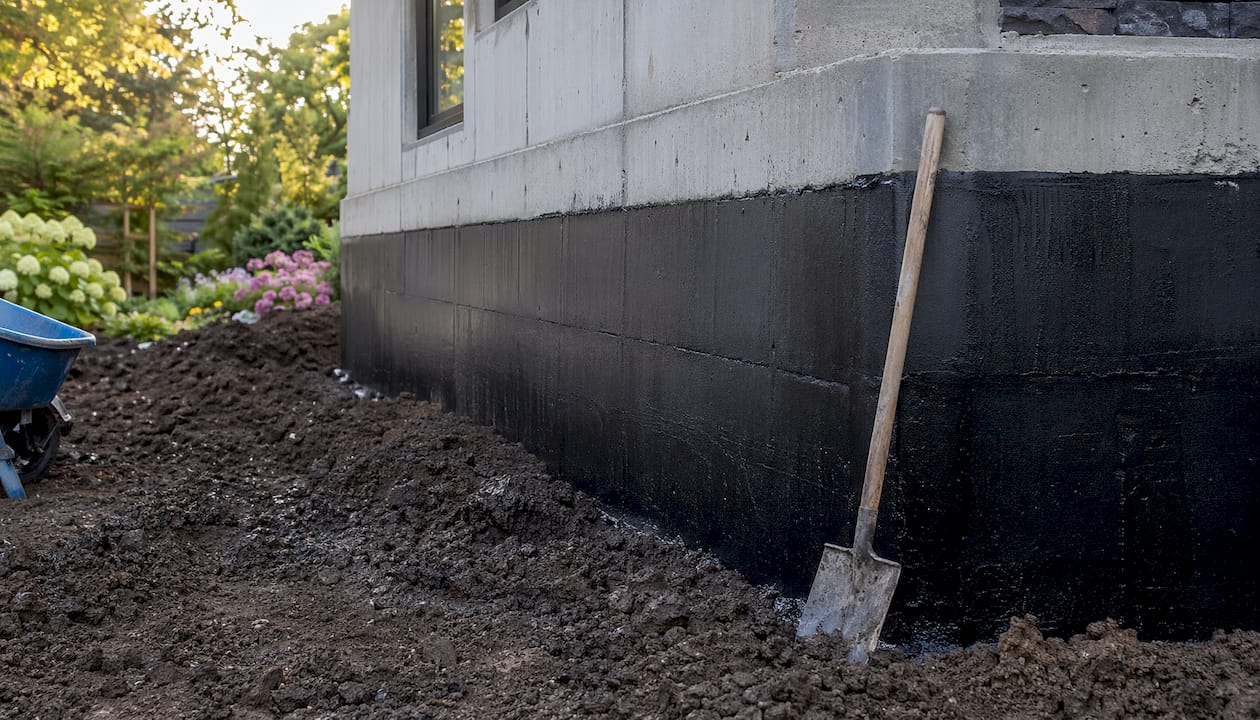 Exterior foundation with waterproofing membrane and soil backfill