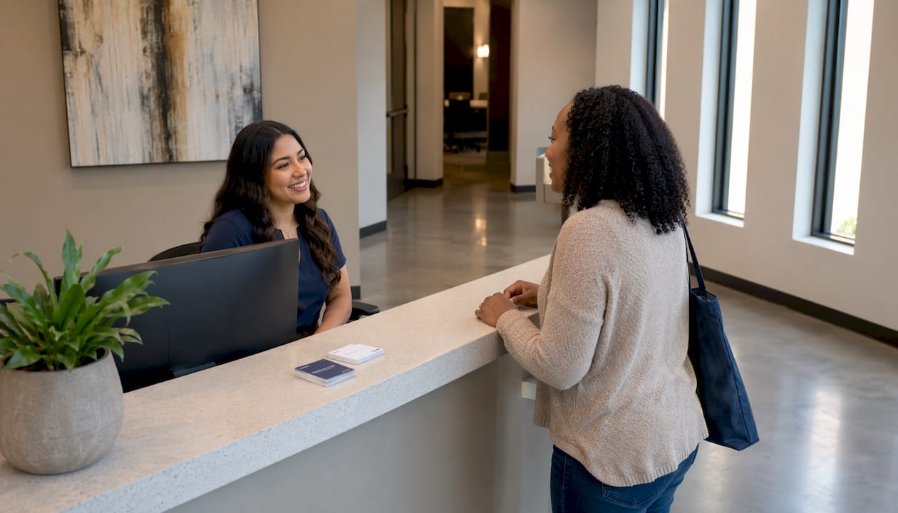 Receptionist helping dental patient at front desk