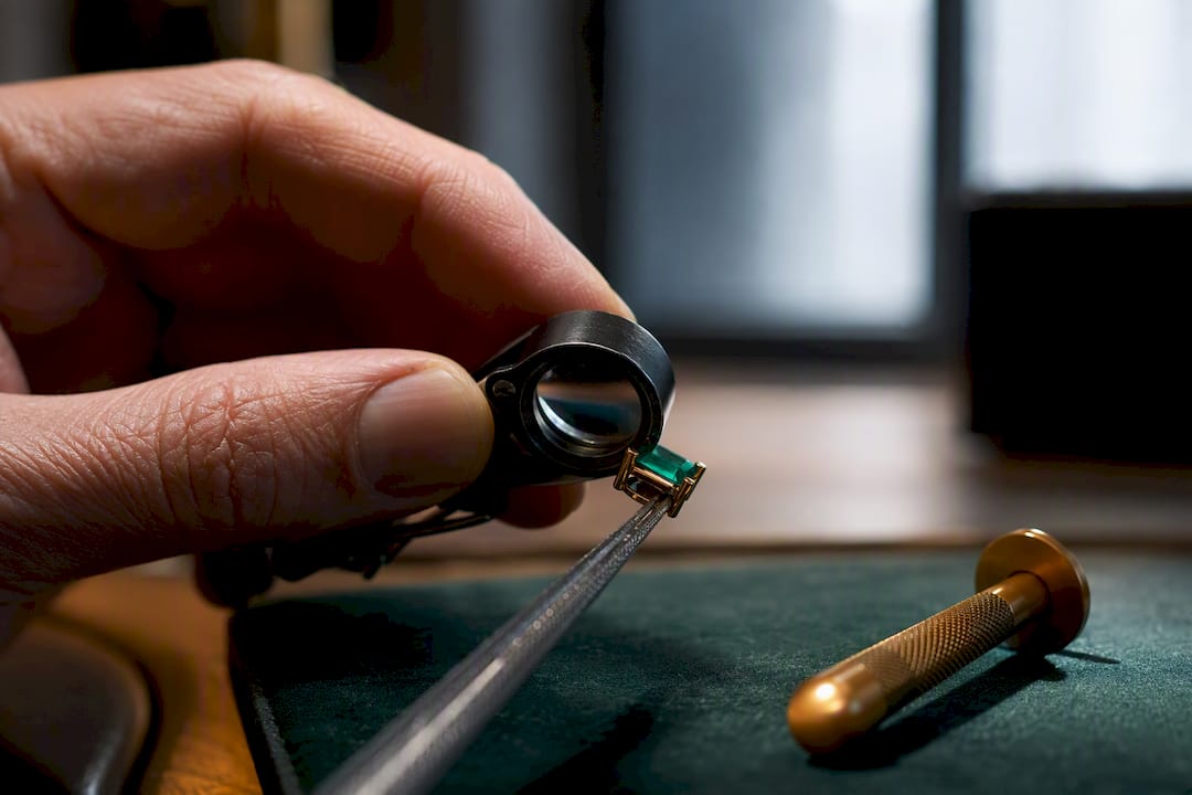 Loupe examining emerald setting protection