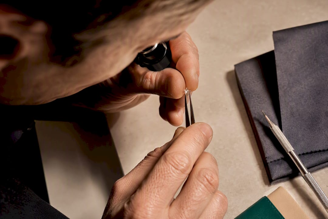 Joyero inspeccionando las garras de un anillo bajo luz brillante