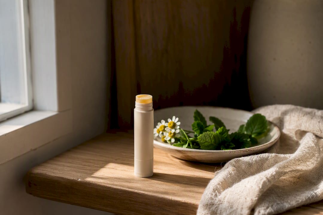 Lip balm stored on wooden shelf with herbs