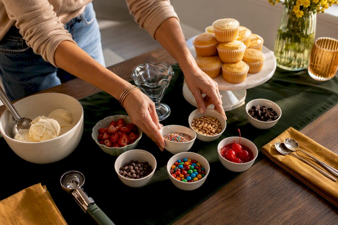Hands arranging a build-your-own dessert station