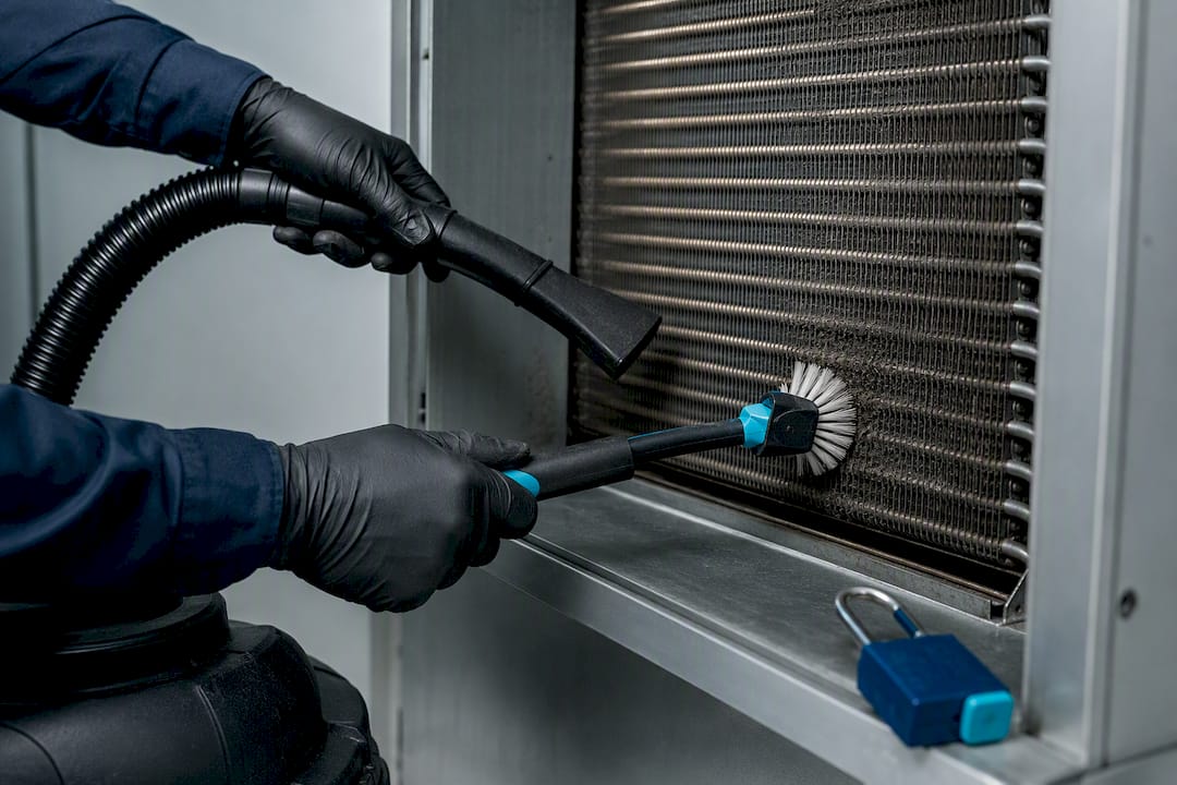 Technician brushing debris from cooler coil