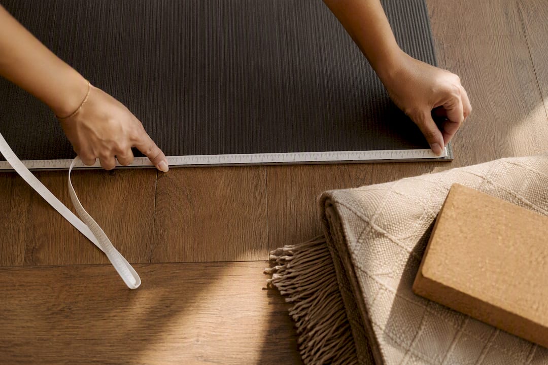 Hands measuring a yoga mat length