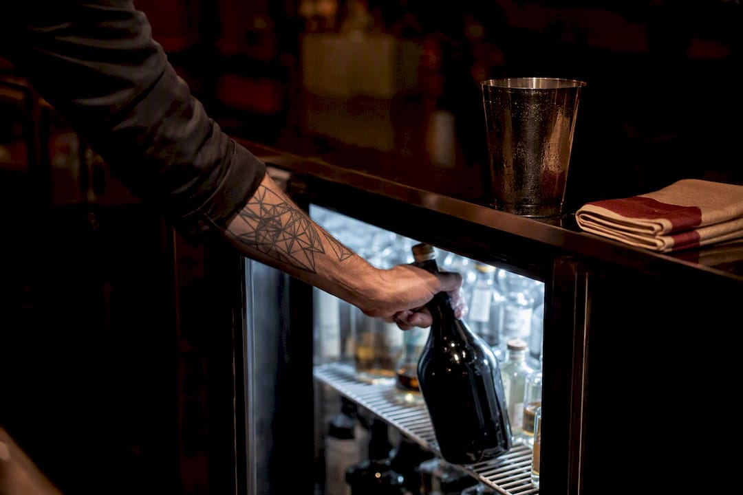 Barman odkłada wermut do lodówki
