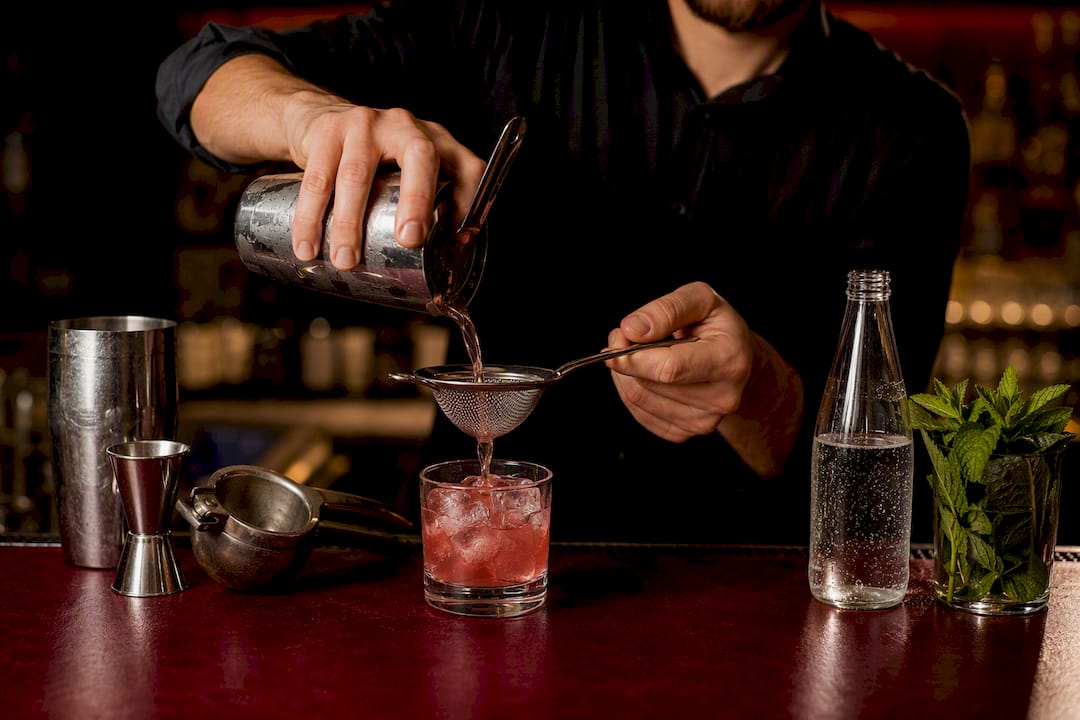 Przelewanie mocktailu przez sitko do szklanki