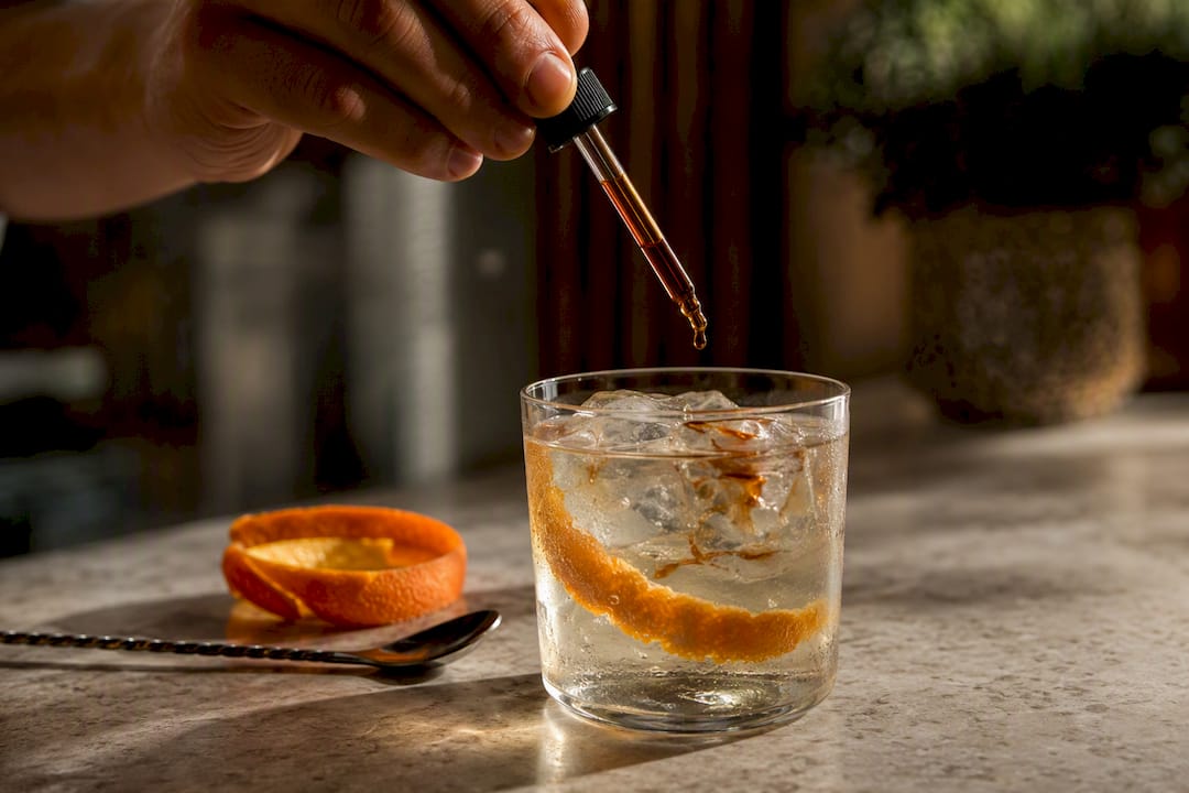 Barrel-aged bitters added to citrus gin serve