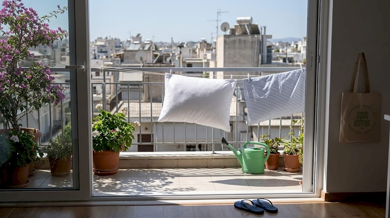 Tips για καθαρισμό μαξιλαριών: πλήρης οδηγός 2 Μαξιλάρι απλωμένο στο κάγκελο του μπαλκονιού να το βλέπει ο ήλιος