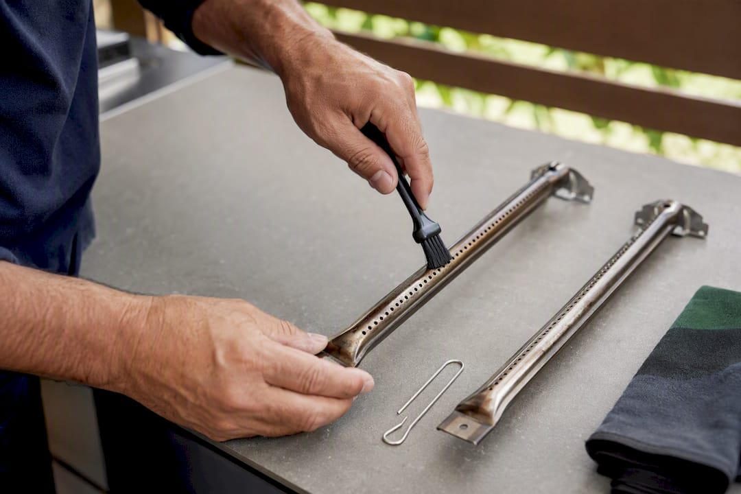 Brushing debris from gas BBQ burner ports