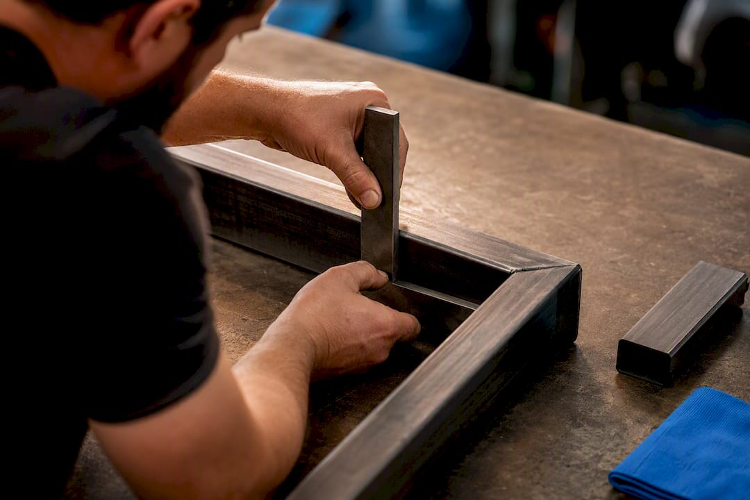 Fabricator checking steel gate-frame alignment