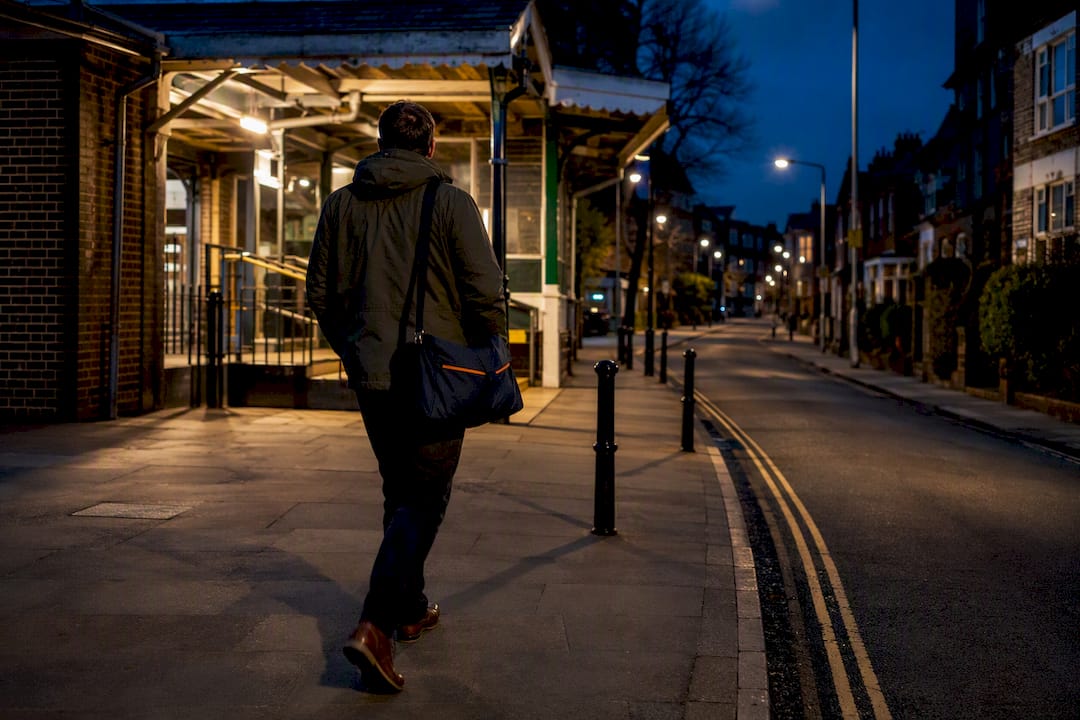 Commuter walking along lit residential street