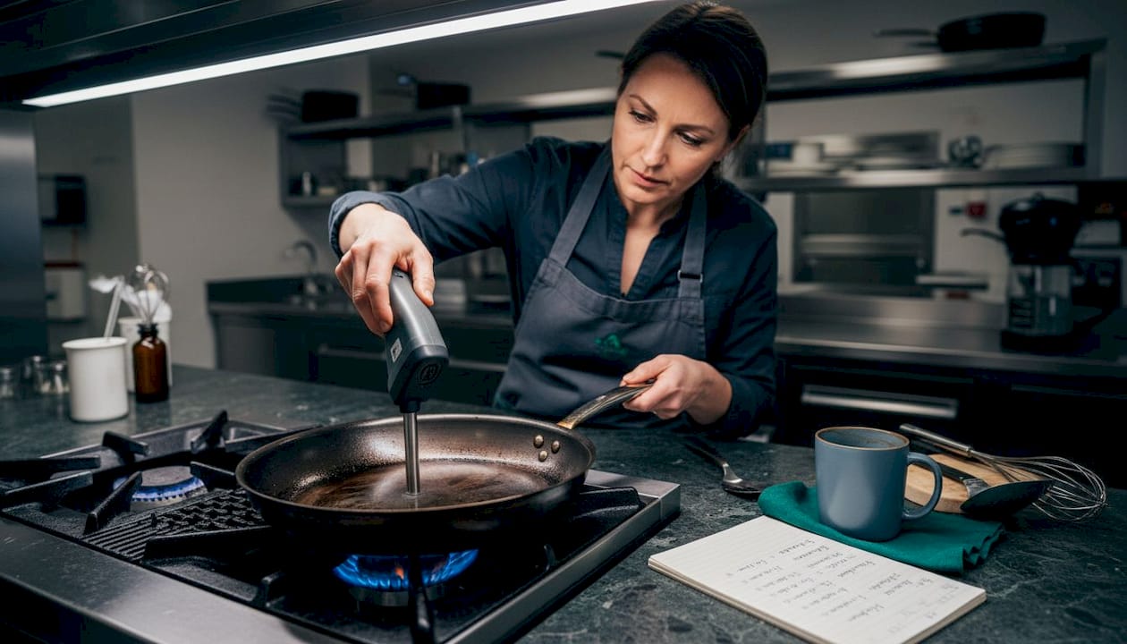 Chef checks pan heat distribution