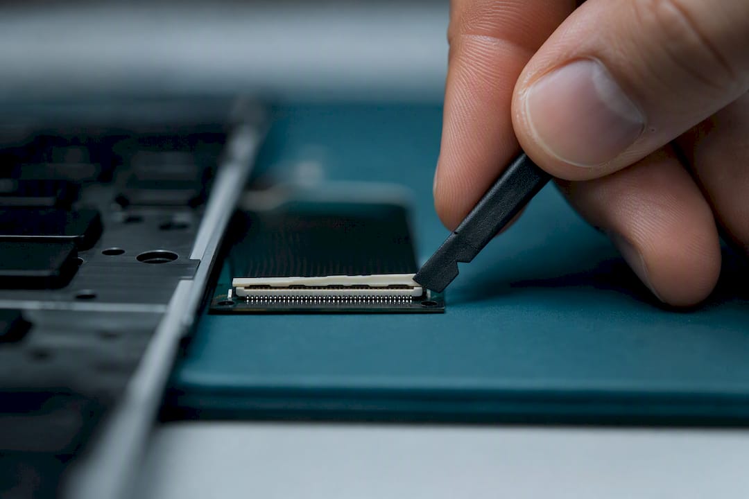 Technician unlocking a keyboard ribbon connector