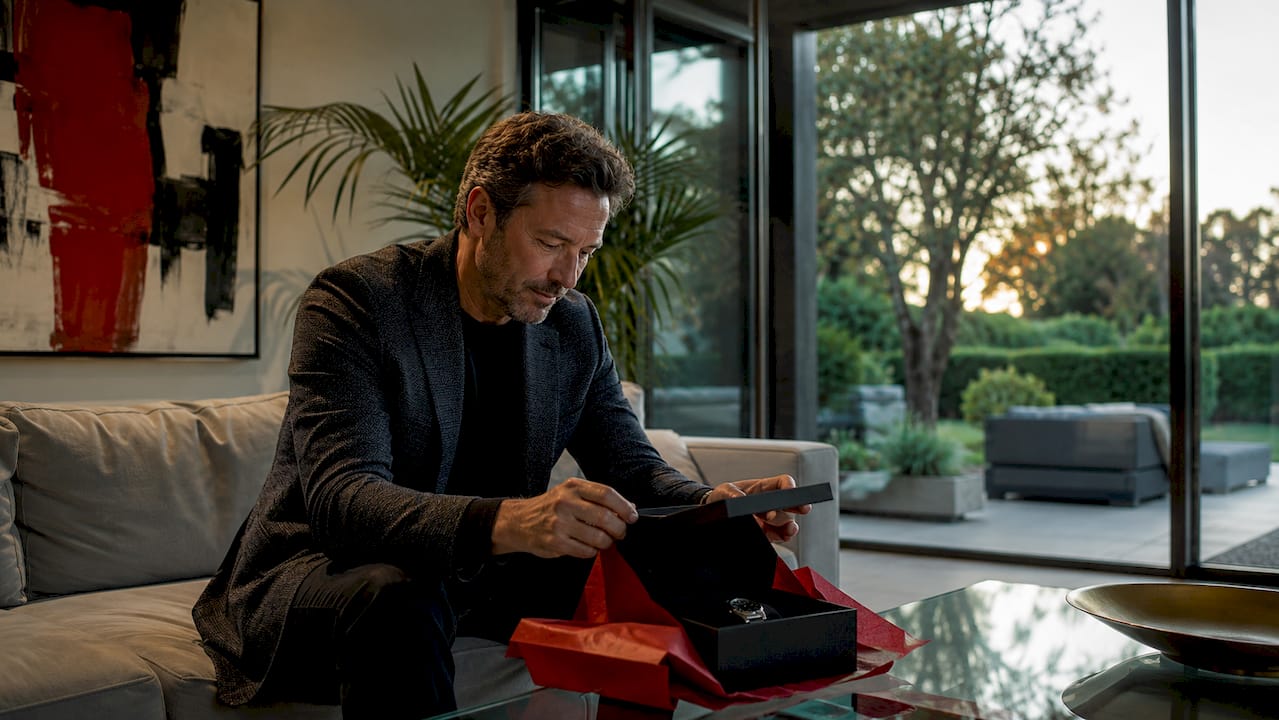 Hands unwrapping luxury watch box