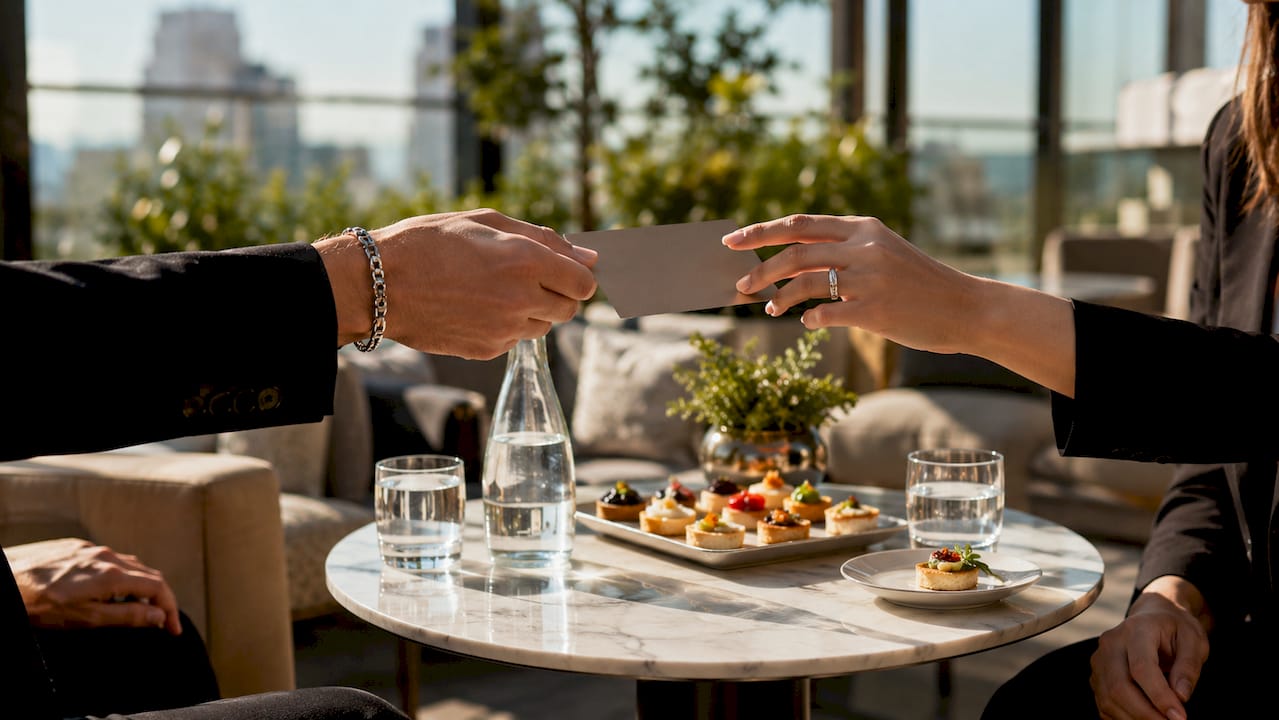 High-End Customer Loyalty: A Guide for Luxury Brands Hands exchanging luxury VIP event invitation