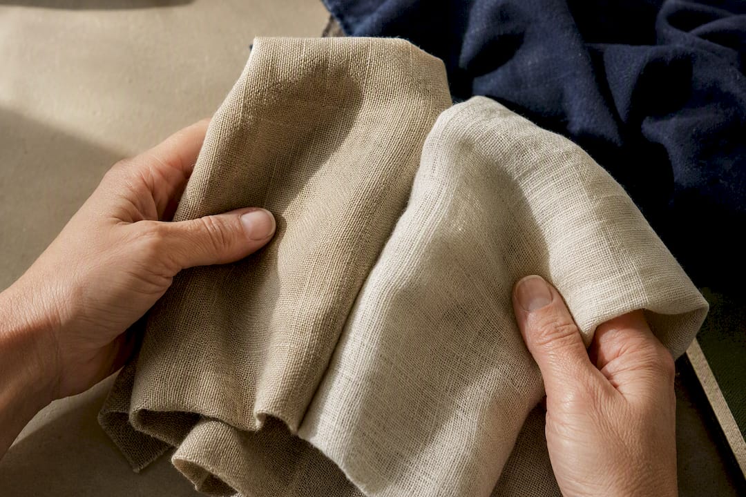 Hands comparing breathable hemp and linen fabrics